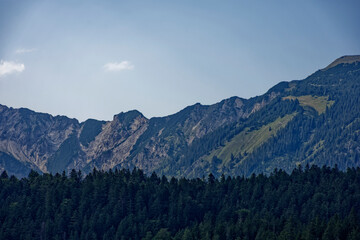 Fototapeta premium Mountain View Through Alpine Forest Framed by Dramatic Cloudy Sky Near Zugspitze