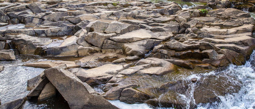 Water stream rapids flowing over flat stone surface background