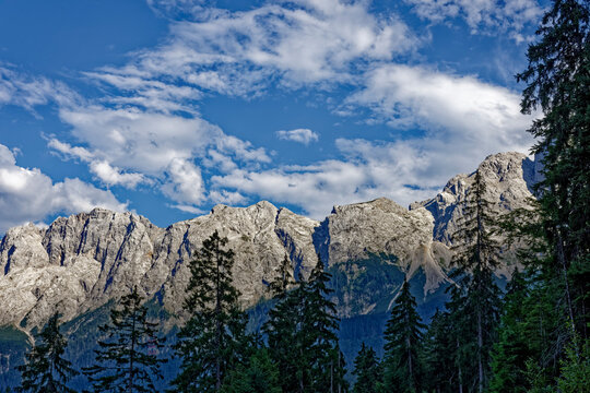 Mountain View Through Alpine Forest Framed by Dramatic Cloudy Sky Near Zugspitze