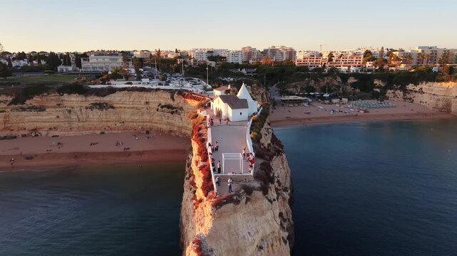 Aerial view of Nossa Senhora da Rocha chapel at sunset in Armacao de Pera Algarve Portugal