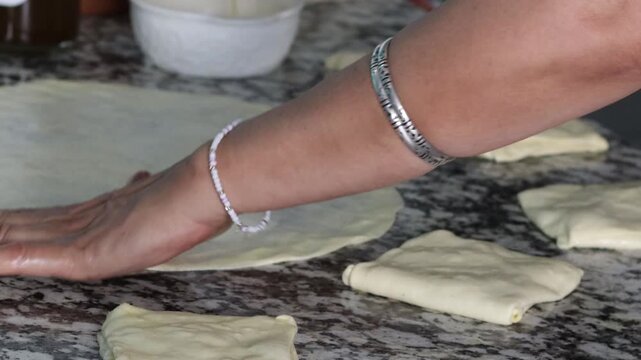Spreading oil on thin msemen dough before folding