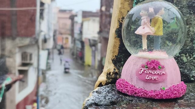 Pink decorative snow globe with ballerina figurine and forever love message on city ledge