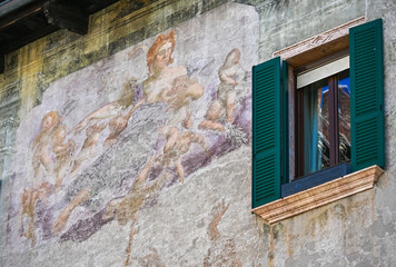 Weathered Renaissance fresco beside green shutters on historic Verona facade © S J Lievano