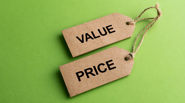 Craft paper tags with value and price text laid on vibrant green background symbolize retail commerce business economy and consumer decision making