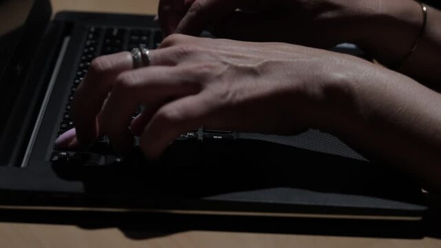 Close-up view of female hands typing on a laptop keyboard in a modern business office, illustrating professional work, technology, productivity, and digital communication