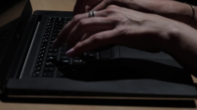 Close-up view of female hands typing on a laptop keyboard in a modern business office, illustrating professional work, technology, productivity, and digital communication