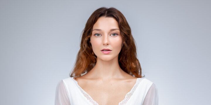 Studio Portrait Of Young Woman In White Lace Dress With Natural Expression