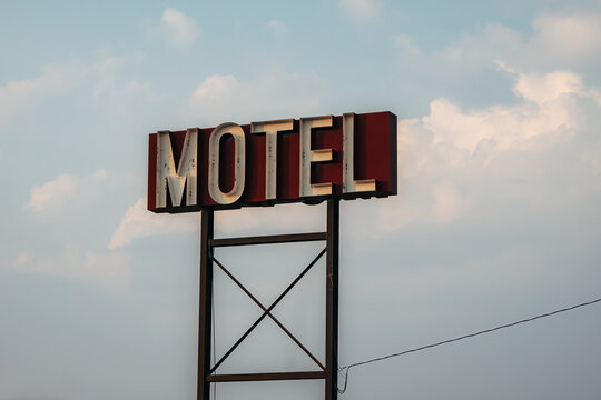 View of a vintage motel sign standing against a cloudy sky in The Dalles, Oregon, United States.