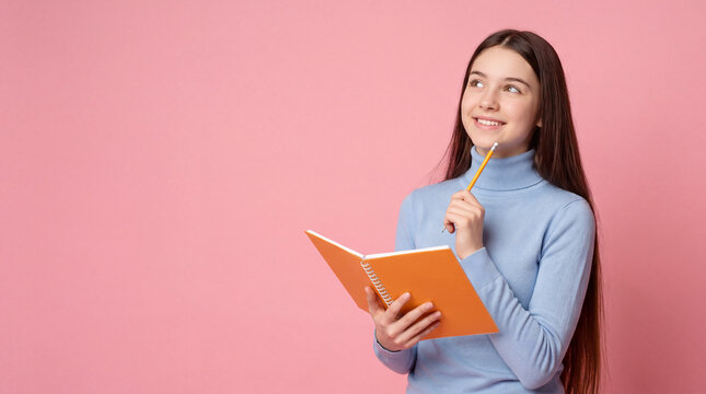 Young girl with long hair holding an orange notebook and pencil, smiling thoughtfully against a pink background