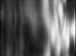 Obraz premium Grungy vintage black and white film scan background with light leaks and grain