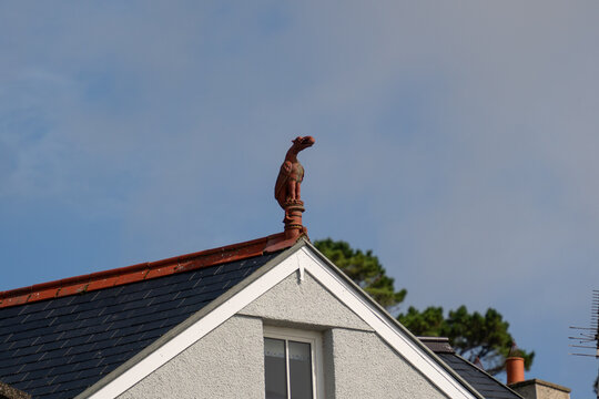 View of a decorative bird finial perched on the roof of a building in Aberdyfi, Wales, United Kingdom.