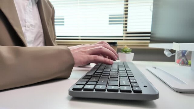 Typing on computer keyboard hands of businessman working at office desk for digital communication, software development and remote business data entry