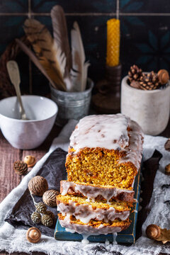 Pumpkin raisin bread with icing, served with tea on a dark background. Halloween concept.