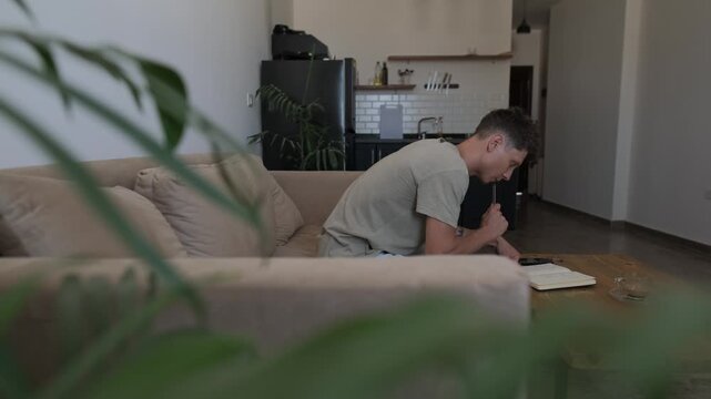 Household expenses and cost of living at home, thoughtful man reviews handwritten notes and everyday bills while organizing personal finances in an authentic candid lifestyle moment