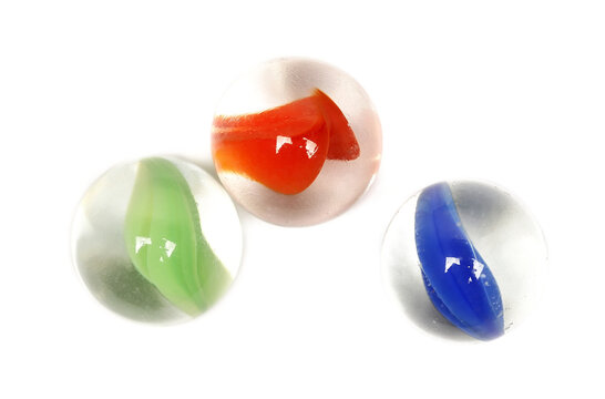  Close up colorful glass marbles grouped together isolated on white background, top view