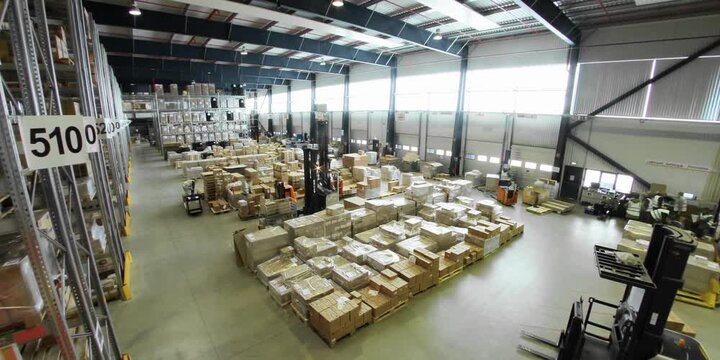 Large distribution warehouse facility filled with various cardboard boxes stacked on metal industrial racks for storage and inventory management operations in a busy logistics center during