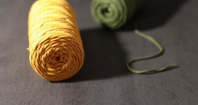 Rolled yellow and green yarn on a neutral background, textile materials for crafts. 
