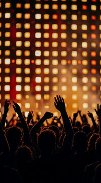 Concert Crowd Silhouette Raising Hands with Glowing Stage Lights