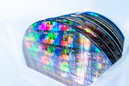 patterned silicon wafers in plastic holder box. Electronic circuit designs have been built onto the wafers using micromaching including photolithography