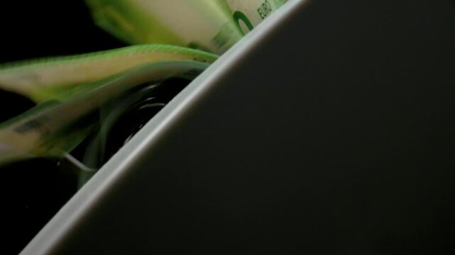 Extreme macro shot of 100 Euro banknotes in a rapid cash counting machine