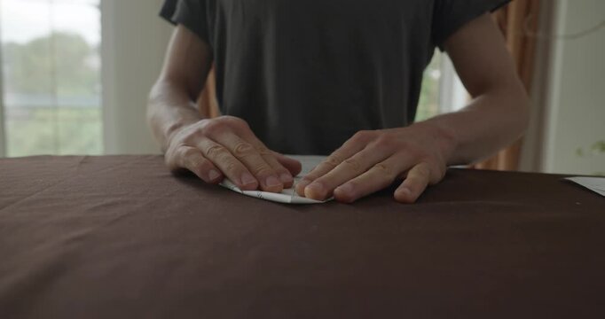 Close-up male hands fold sheet of paper making paper airplane. 4K 10-bit