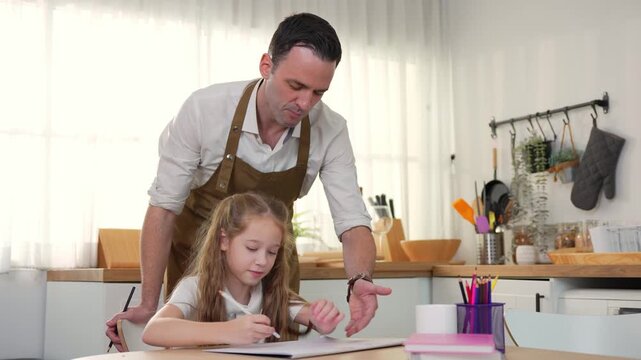 Father helping his daughter with homework in the kitchen, Dedicated father assisting young girl with study assignment at home, Caring dad supporting daughter during home learning session