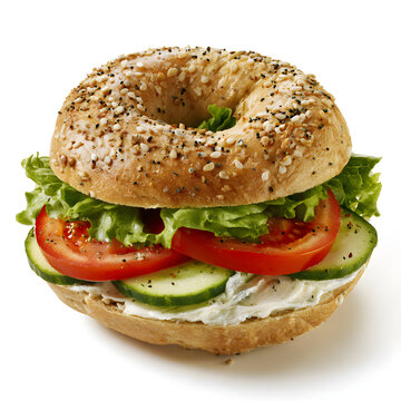 A fresh bagel sandwich crammed with a creamy cheese spread, lettuce, tomato, and cucumber slices, served as a healthy vegetarian meal option, presented on a white background. A deliciously simple dish