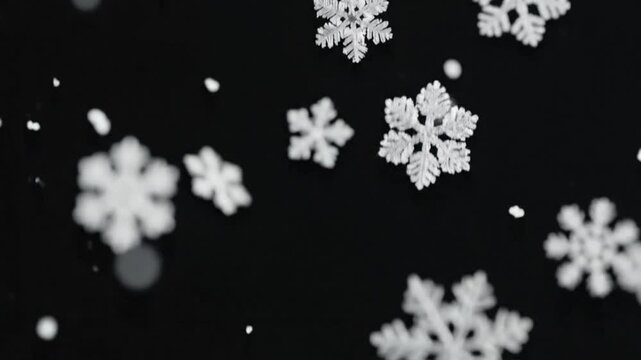 Graceful snowflakes falling against a dark backdrop in winter, creating a serene and captivating display.