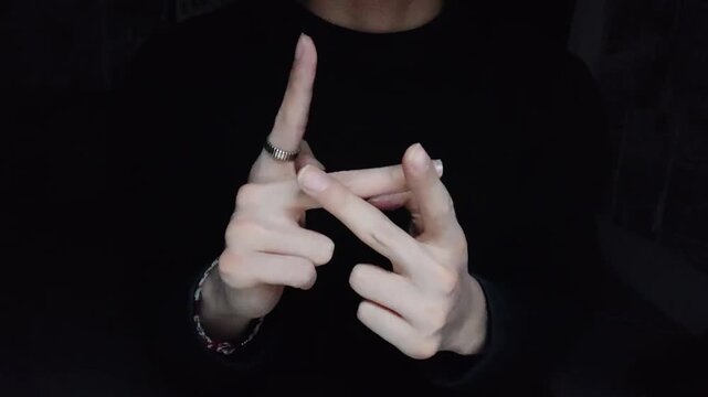Close-up of hands forming a gesture against a dark minimalist black background