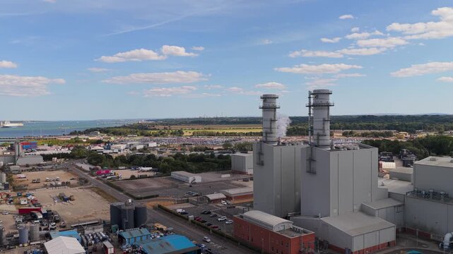 Industrial Power Plant Facility With Tall Smoke Stacks and Surrounding Shipyard