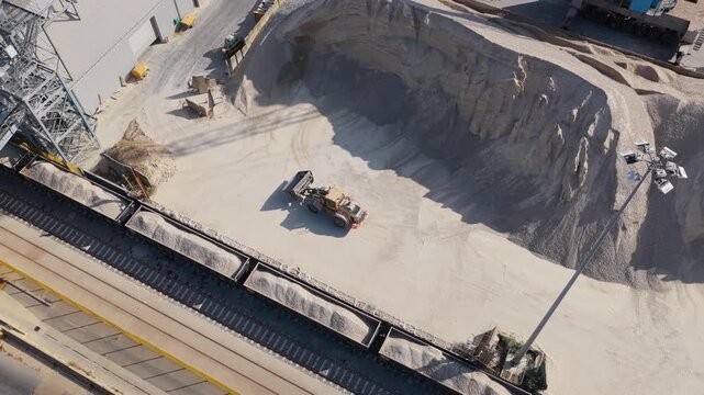 Front End Loader Moving Gravel in a Large Industrial Quarry Yard During the Day