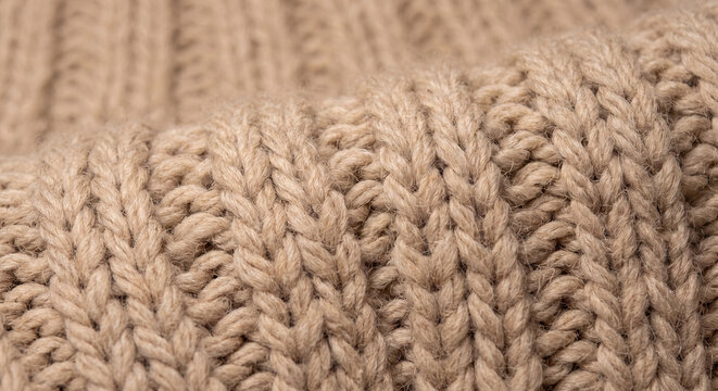 Chunky knit wool texture macro photo of beige ribbed sweater for cozy background