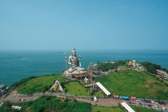 A breathtaking top view of the scenic Gokarna coastline in Karnataka, India, featuring a beautiful sandy beach, turquoise sea, dramatic rocky shoreline, and lush green landscape.
