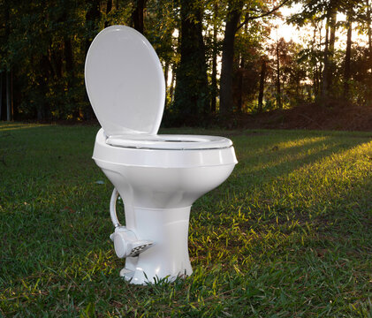 Early moring camper trailer toilet outside and on a field