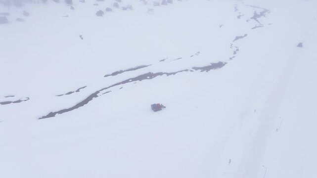 Aerial view of a snowcat in the snowy landscape of Bakhmaro, Georgia.