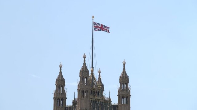 Palace of Westminster and Union Jack waving in the wind
