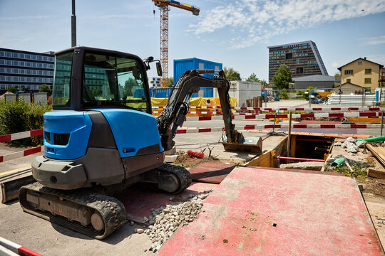 Excavator at urban construction site with heavy machinery, earthmoving work, trench excavation, building development and infrastructure construction in a city