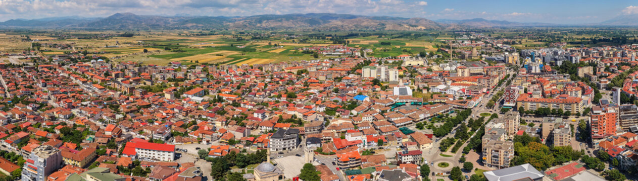Korce rooftops and boulevards beside agricultural fields