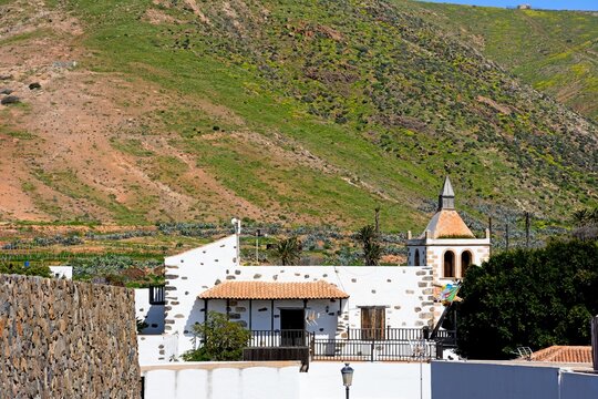 Santa Maria church tower with town buildings and pretty countryside in the Springtime, Betancuria, Fuerteventura, Canary Islands, Spain, Europe.