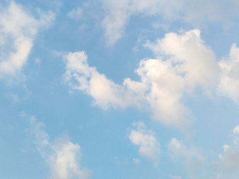 Soft white clouds floating in bright pastel blue sky create gentle and airy backdrop for subtle environmental theme.