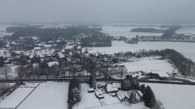 Winter aerial view of the village of Elp in Drenthe, showing the gas station along the N374 road and the regional highway leading out through snowy farmland
