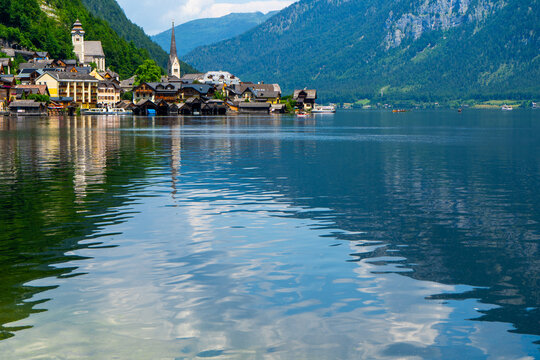 Houses on a Mountain by Lake in Hallstatt Village Austria. Embankment near blue water.