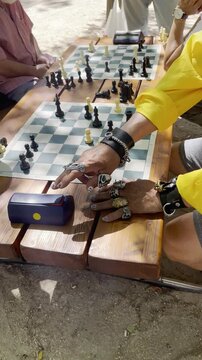 Ajedrez partida chess con tablero y piezas y mano de jugador con anillos en dedos silbando 