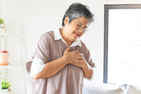 Chest pain, attack chest, emergency heartbeat asian senior woman holding hand on chest, suffering symptom from pain, heart disease problem of aged anxiety cardiac. Health care of cardiology concept.