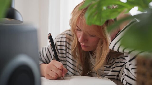 Ambitious teenage student study at home and writing notes at desk, focusing on education and academic goals, representing motivation, learning, personal development, future success ,career preparation