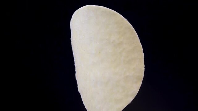 Single Curved Potato Crisp Isolated on Black Background