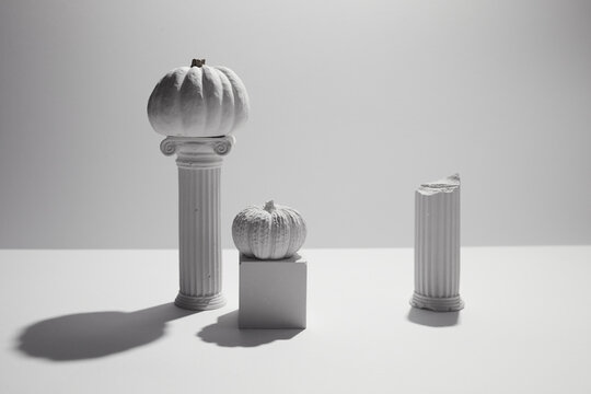 White pumpkins on classical columns still life composition