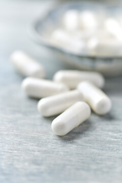 Creatine capsules on wooden background. Soft focus. Close up. Copy space