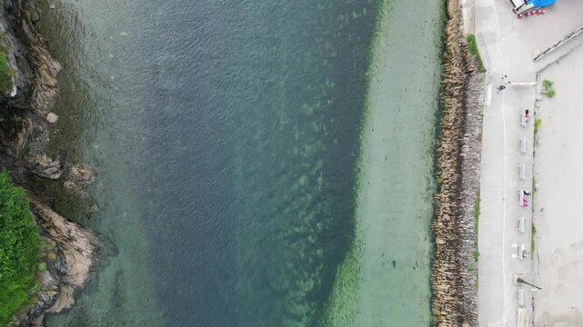 High Angle Footage of Beach and Ocean of Looe Town at River and Beach During Hot Sunny Day June 29th, 2025. Looe is a coastal town and civil parish in southeast Cornwall, England, United Kingdom.