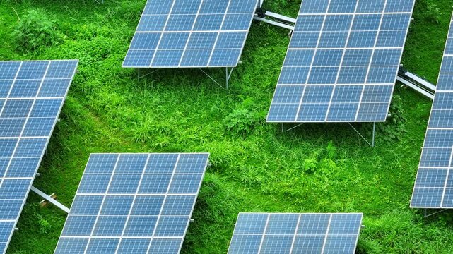 Drone aerial scene of a photovoltaic farm across green vegetation reflects modern clean energy infrastructure, reduced carbon emissions, energy transition and sustainable economic growth. 4k.
